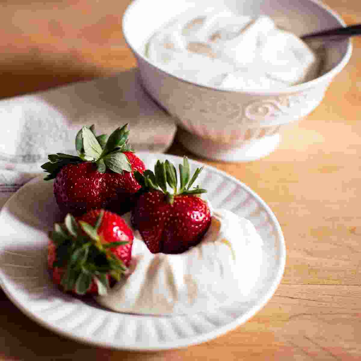 A plate of Strawberries & a bowl oh homemade whip cream.
