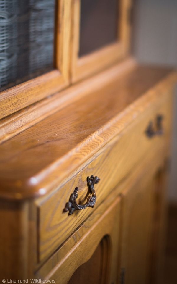 An antique stepback cupboard that is made with maple wood from 1910-1920 with vintage drawer hardware.