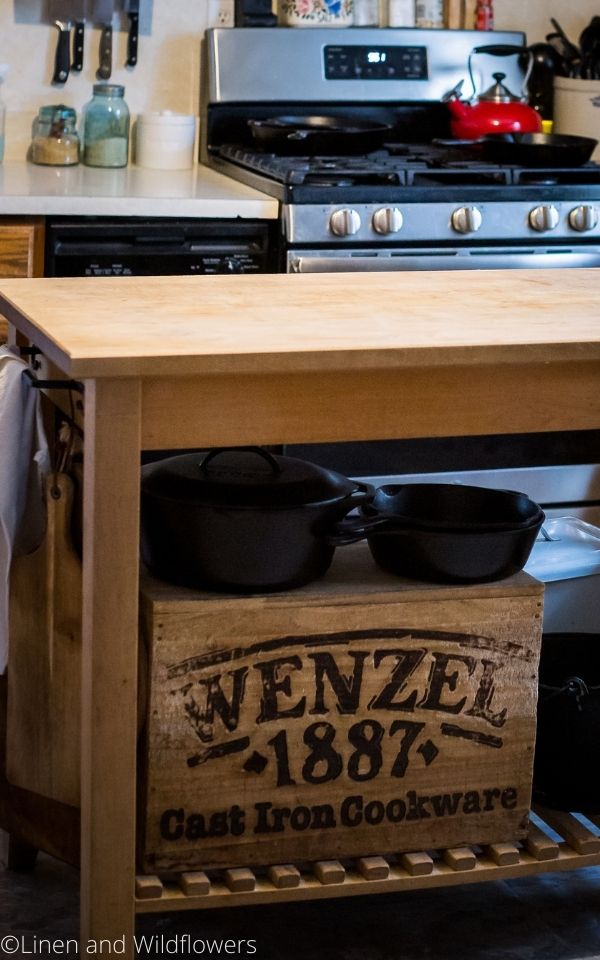 16 Useful Kitchen Tips-A bitcher block with a wood book that says Wenzel 1887 cast iron cookware with cast iron skillets on top in the kitchen,