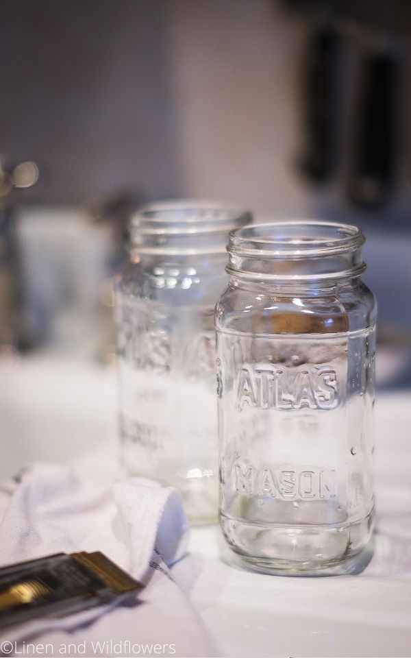 2 empty Atlas mason jars on a drain board with a tea towel & a razor.