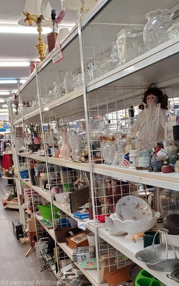 Shelves filled with second hand merchandise at a thrift store for sale.