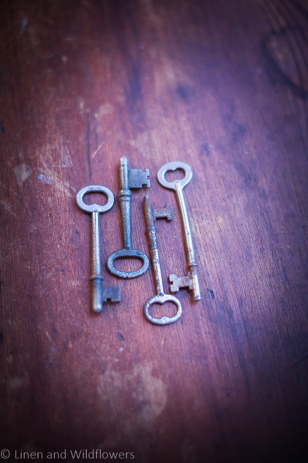 four antique skeleton keys on a wood table
