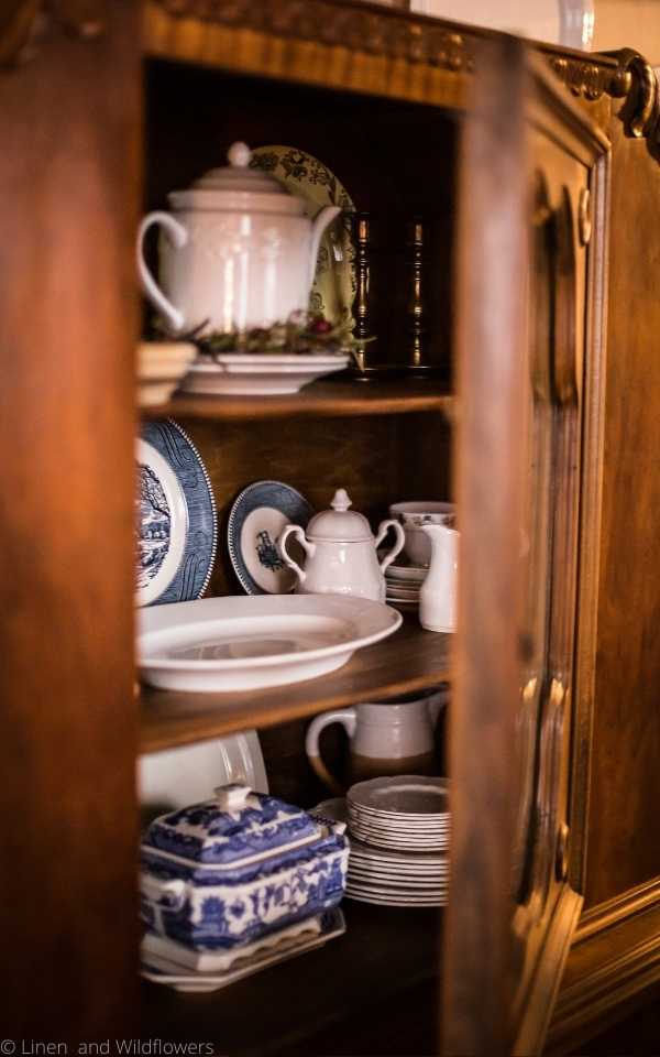 5 Tips for Using an Antique China Cabinet. An antique cabinet with the glass door slightly opened to display of the China & ironstone dishes.
