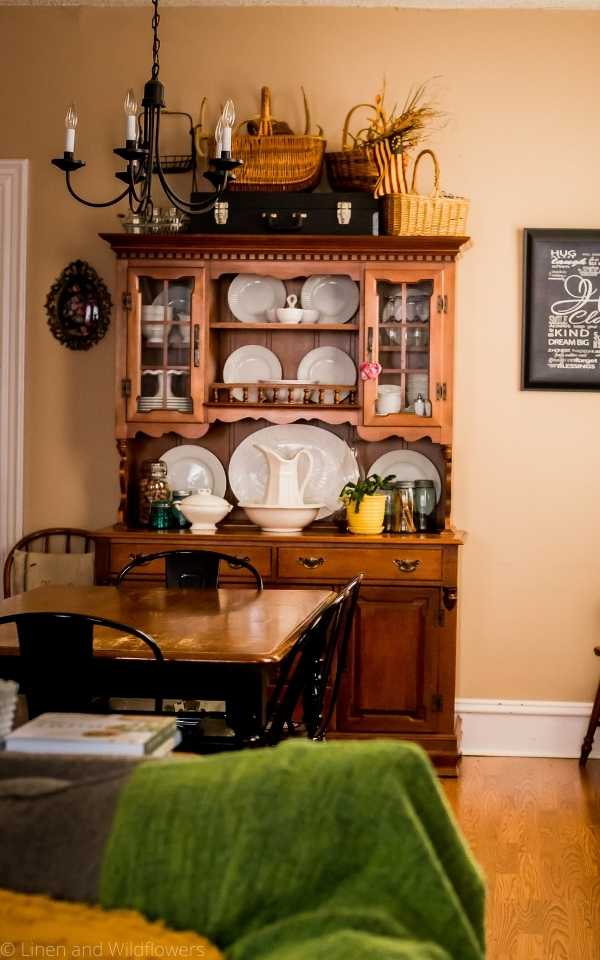 The Art of Styling Your Home-A hutch filled with china displayed along with antique mason jars, pitcher & bowl, christmas cactus in a yellow planter & an ironstone gravy boat.