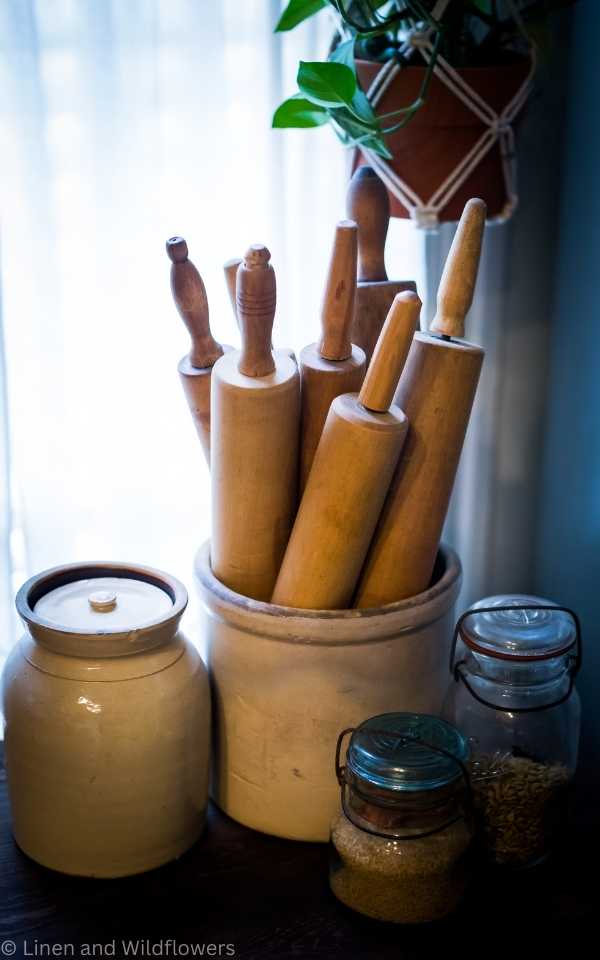 Creative Ways to Use Vintage Crocks is using them in the kitchen to store kitchen utensils.