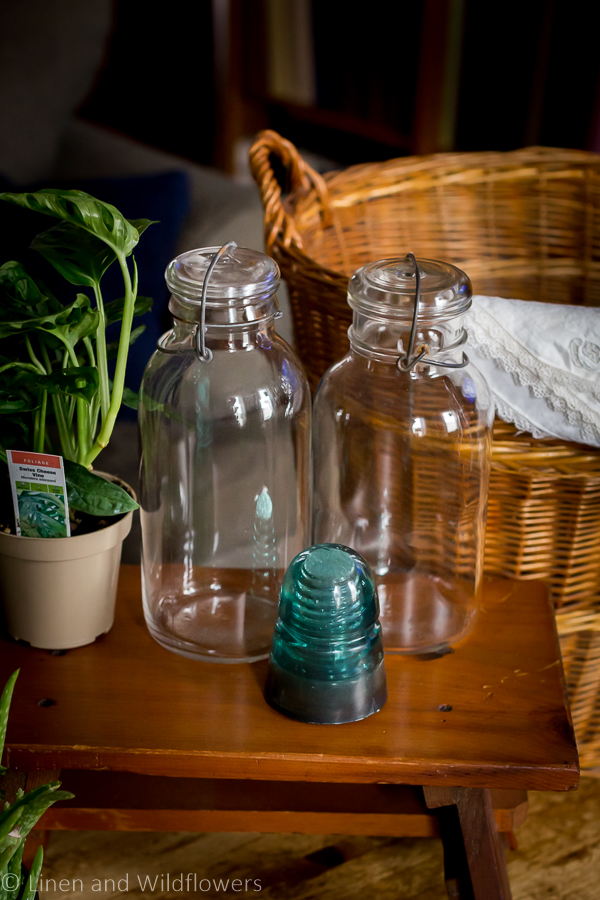 Large antique mason jars, railroad insulator, houseplant, wicker basket & linen napkins for a birthday antique haul.