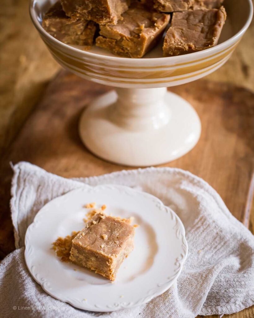 Easy Peanut Butter Fudge Recipe=Plate of sliced peanut butter fudge & a a pedestal of peanut butter fudge..