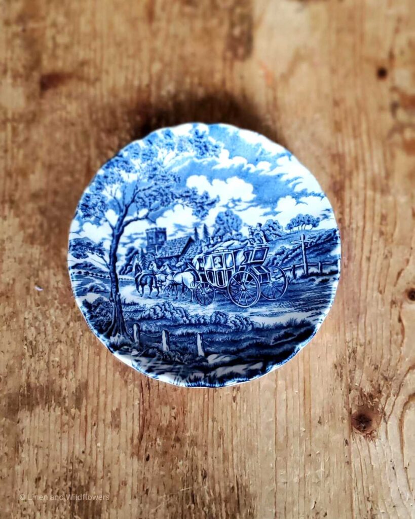 blue & white plate with a picture of a wagon & horses.