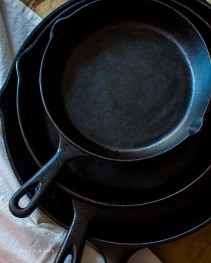 A stack of three cast iron skillets.