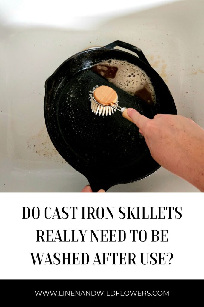 scrubbing a cast iron skillet with a soft bristle wooden brush.