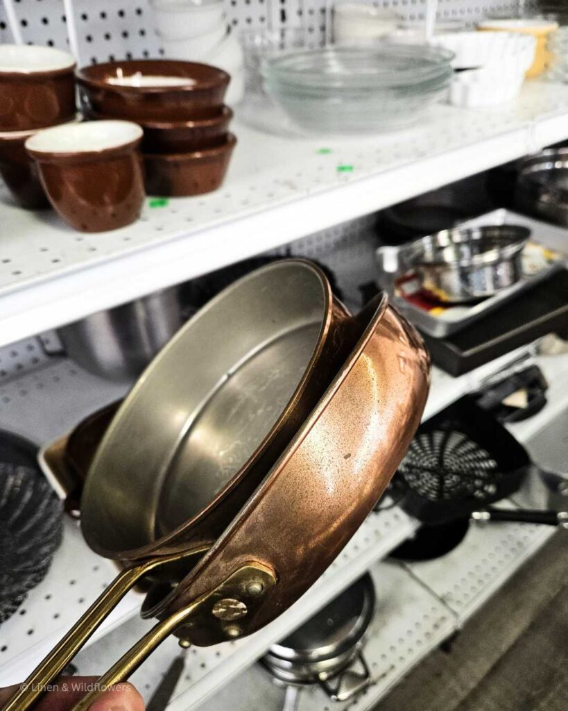 Dusty from LinenandWildflowers.com holding two copper skillets