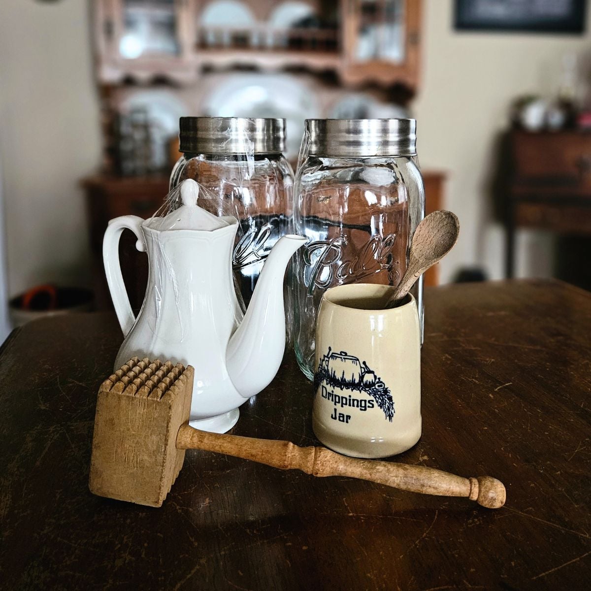 Thrift and antique haul featuring a vintage ironstone teapot, Ball mason jars, and a drippings jar crock styled for intentional home decor.
