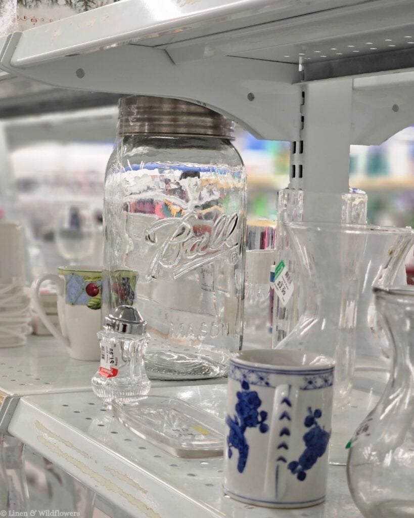 Vintage large Ball mason jar and antique glassware spotted on a thrift store shelf while treasure hunting for home décor.