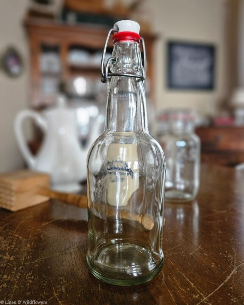 Vintage glass swing-top bottle with ceramic stopper, a thrifted find perfect for styling a farmhouse kitchen counter.
