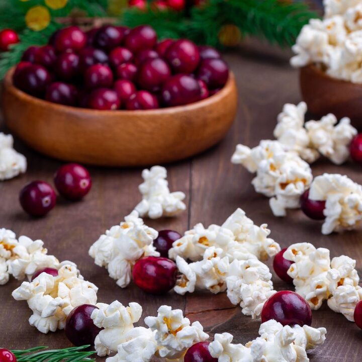 two wood bowls each filled with cranberries & popcorn to make a homemade Christmas tree garland.