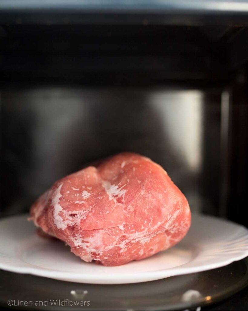 Thawing a frozen roast in the microwave.