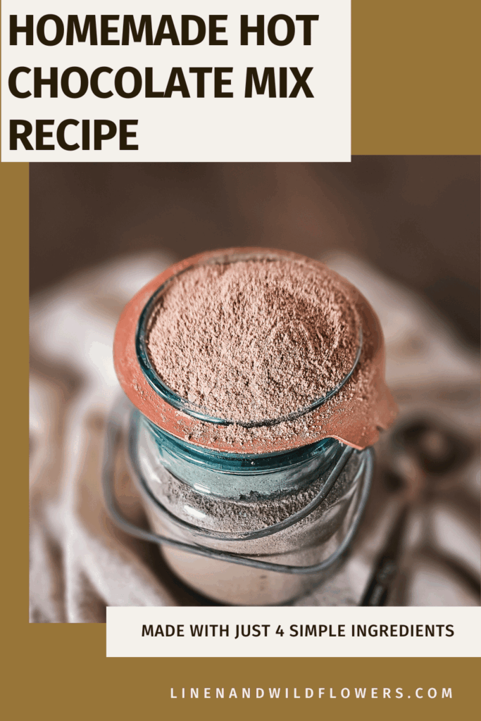 A jar filled with homemade hot chocolate mix topped with cocoa powder, set on a cloth. Accompanied by text: "Homemade Hot Chocolate Mix Recipe" and "Made with just 4 simple ingredients." The website "linenandwildflowers.com" is displayed. Cozy and inviting.