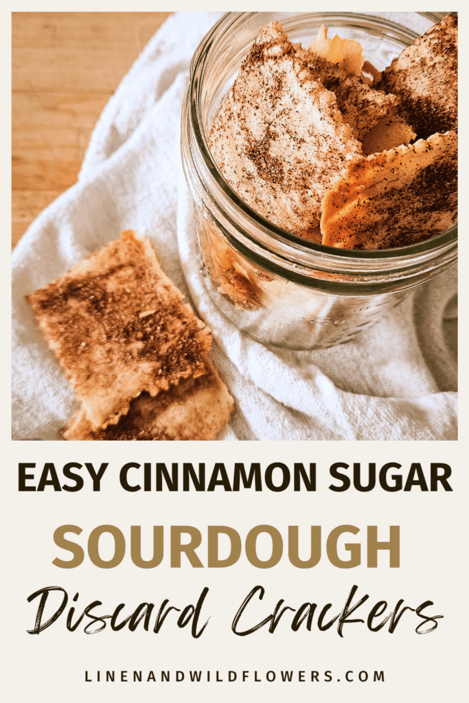 Glass jar filled with cinnamon sugar sourdough discard crackers on a white cloth, set on a wooden surface. Text reads “Easy Cinnamon Sugar Sourdough Discard Crackers.”
