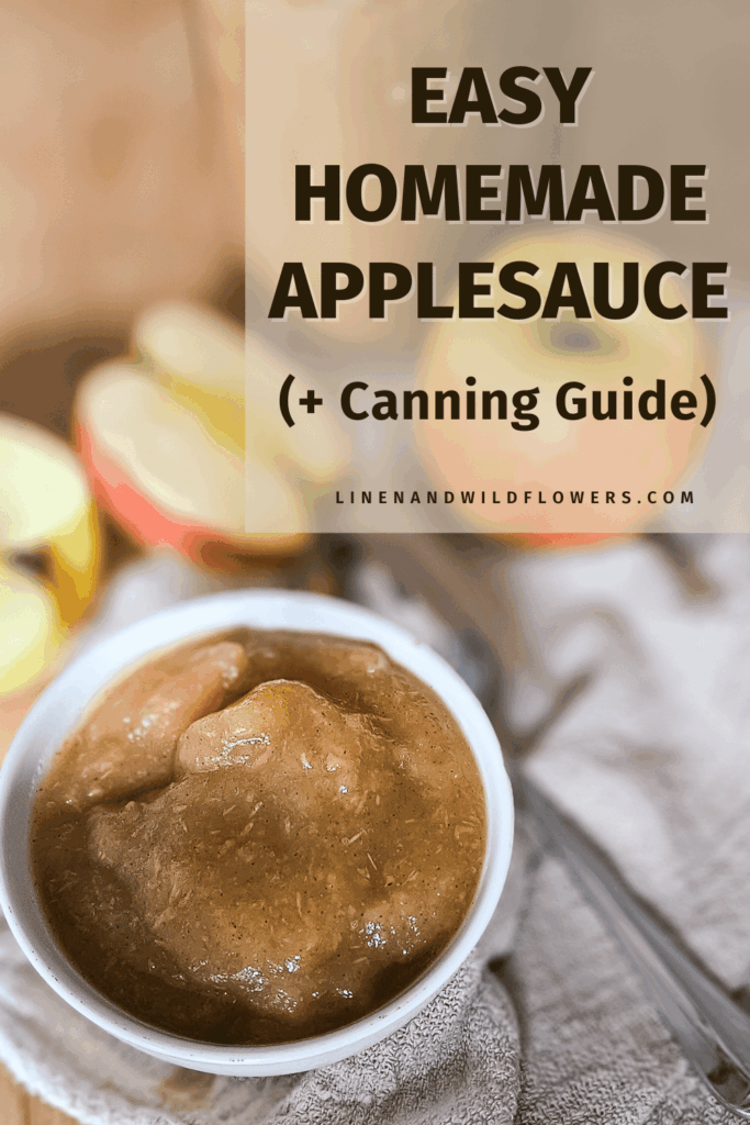 Bowl of homemade applesauce on a cloth, with apple slices in the background. Text overlay reads "Easy Homemade Applesauce (+ Canning Guide)."