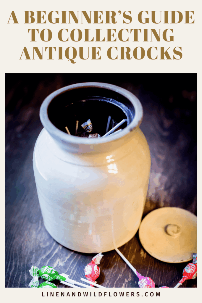 Antique crock filled with lollipops on a wooden surface, lid aside. Text above reads "A Beginner’s Guide to Collecting Antique Crocks."