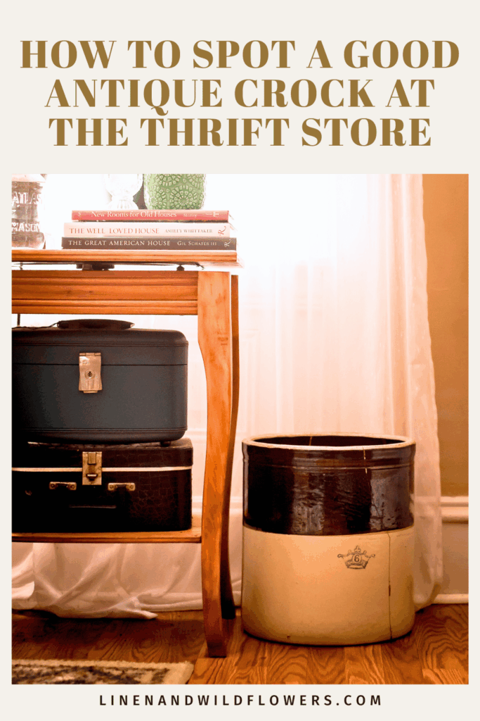 Alt text: "Cozy scene with a wooden table holding suitcases and books. An antique crock sits beside it. Warm, inviting tone with natural light."