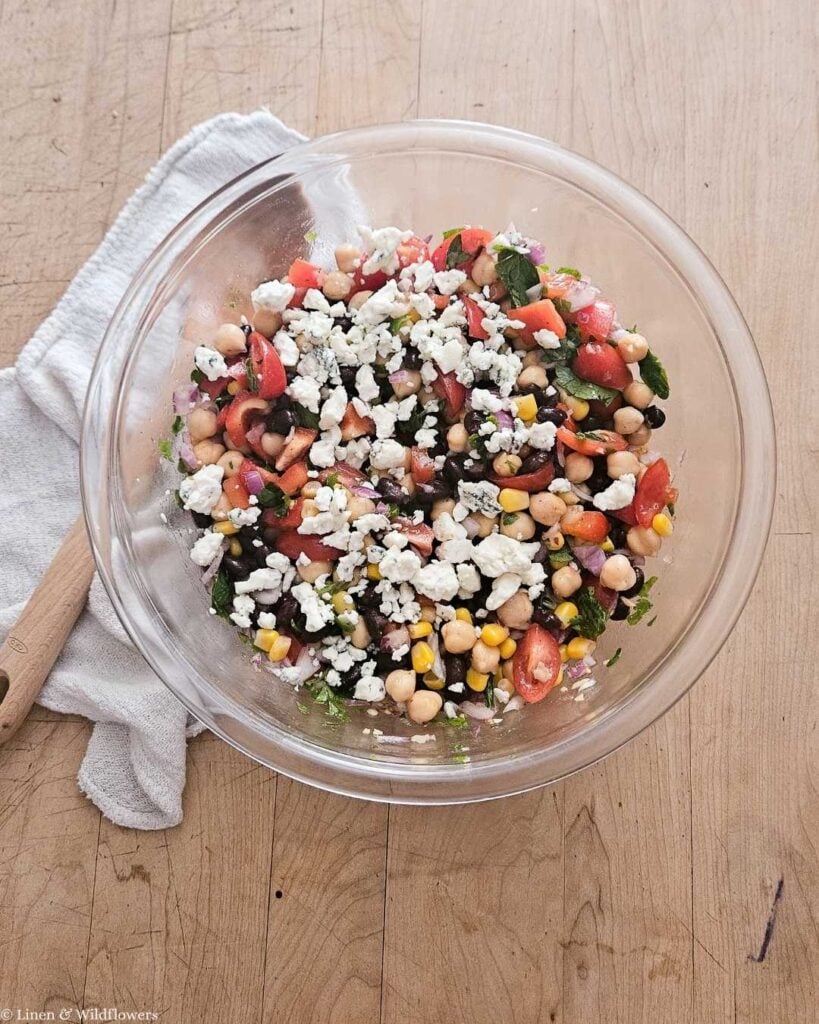 Overhead view of finished chickpea salad with lemon topped with crumbled blue cheese.