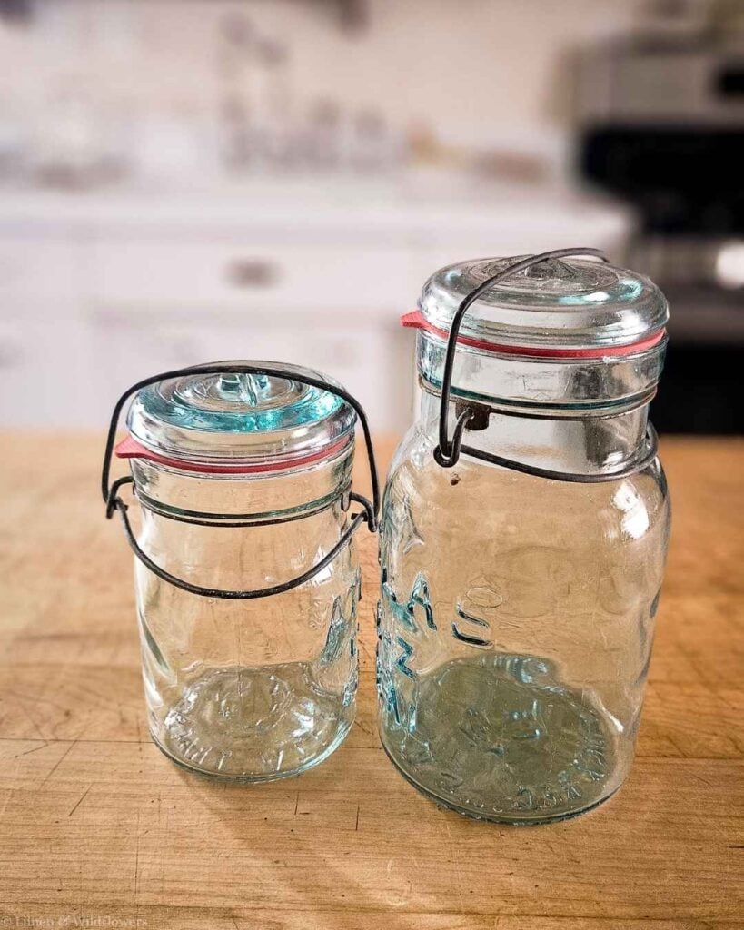 Two vintage Atlas glass jars sealed with wire bails and rubber gaskets.
