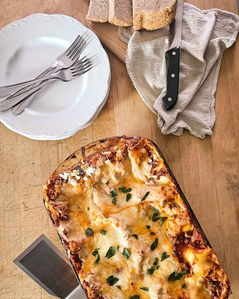 Overhead view of baked homemade turkey lasagna with golden bubbly cheese and fresh parsley.