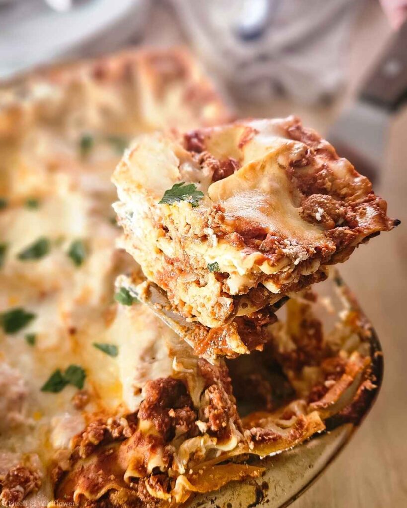 Featured image of homemade turkey lasagna slice being lifted with a melty cheese pull.