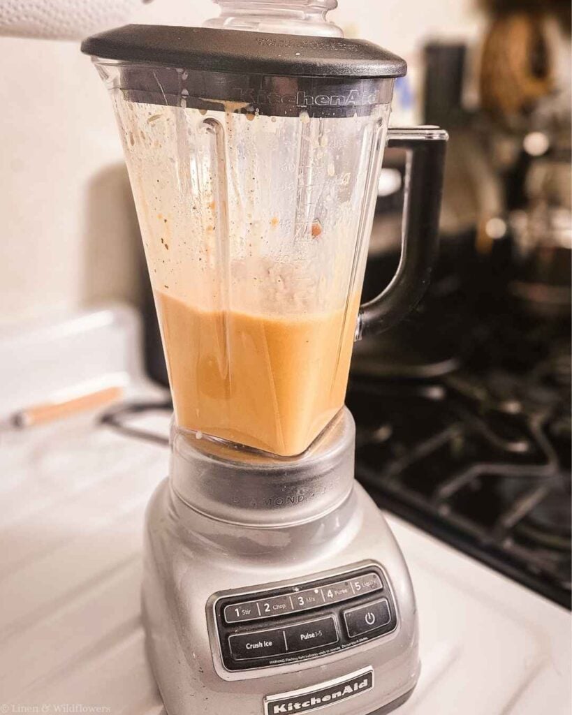Creamy blended pumpkin pie smoothie in a KitchenAid blender, ready to pour.