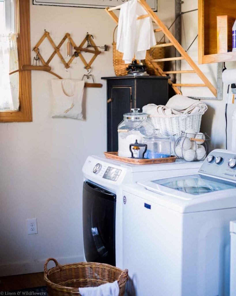 Laundry room with washer, dryer, wool dryer balls, and a vintage wooden drying rack to save time on laundry day.